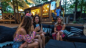 Un área de estar al aire libre con un bar y un cartel que dice 'Thirsty's'.