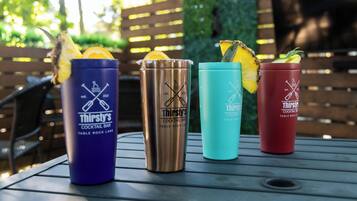 Cuatro vasos de bar estilo 'Four Thirsty's' sobre una mesa al aire libre.