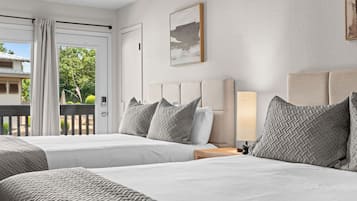 Una habitación de hotel con dos camas, vistas al exterior y un cuadro en la pared.
