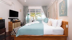 A modern hotel room with a bed, TV, and a view of the sea. - Wander at Bayside 19 | Upstairs Sea-View Room, bathtub & sunset (sleeps 4) (Hua Hin)