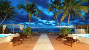 A beachside lounge with a pool, palm trees, and a view of the ocean. - Wander at Bayside 19 | Upstairs Sea-View Room, bathtub & sunset (sleeps 4) (Hua Hin)