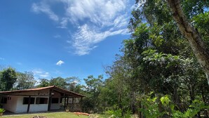 Um edifício com uma placa que diz 'BANHO D'AZEAU', numa área gramada com árvores e céu limpo.