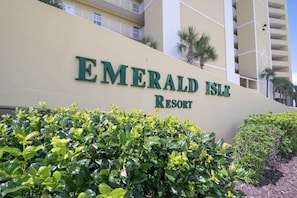 Ein Gebäude mit der Beschilderung 'Emerald Isle Resort', umgeben von gepflegten Büschen.