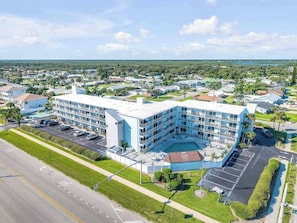 Ein mehrstöckiges Hotel mit Pool, Parkplatz und Blick auf die Umgebung.