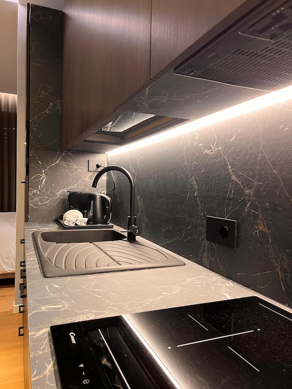 A modern kitchen with a built-in oven, a sink, and a stove.