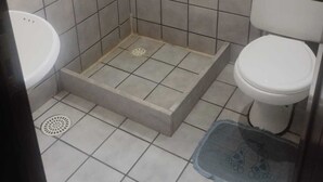 A bathroom with a shower, toilet, and sink. - Hotel Merlini  (Belém)