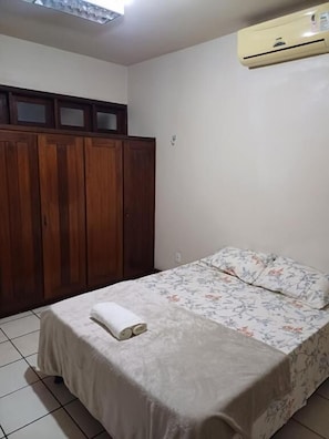Ein Schlafzimmer mit einem Bett, einem Kleiderschrank und einer Klimaanlage.