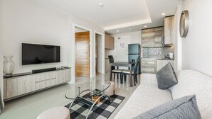Una sala de estar moderna con televisor de pantalla plana, sofá y mesa de centro.
