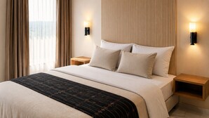 Quarto de hotel com cama, duas mesas de cabeceira e janela com cortinas.
