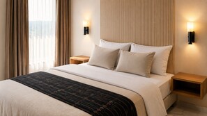 A hotel room with a bed, two bedside tables, a nightstand, and a window with curtains. - Adilia Hotel (Labuan Bajo)