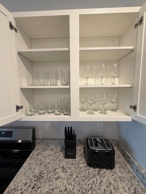 A kitchen with white cabinets, a granite countertop, a toaster, and a knife block. - Spacious 3BR Home with Water Views, Pool Access & Family Amenities (Myrtle Beach)