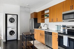 Eine moderne Küche mit Edelstahlgeräten, Holzschränken und einem integrierten Geschirrspüler.