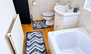 Ein Badezimmer mit Badewanne, Waschbecken, Toilette und Handtuchheizkörper.