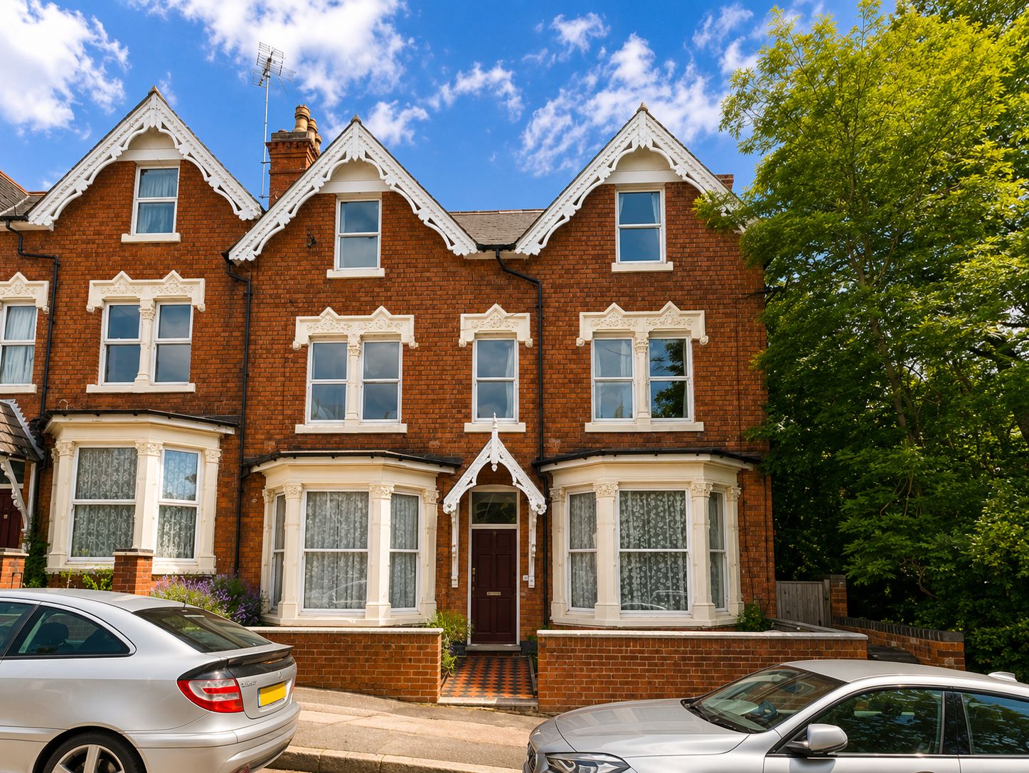A row of terraced houses with bay windows and a central entrance.