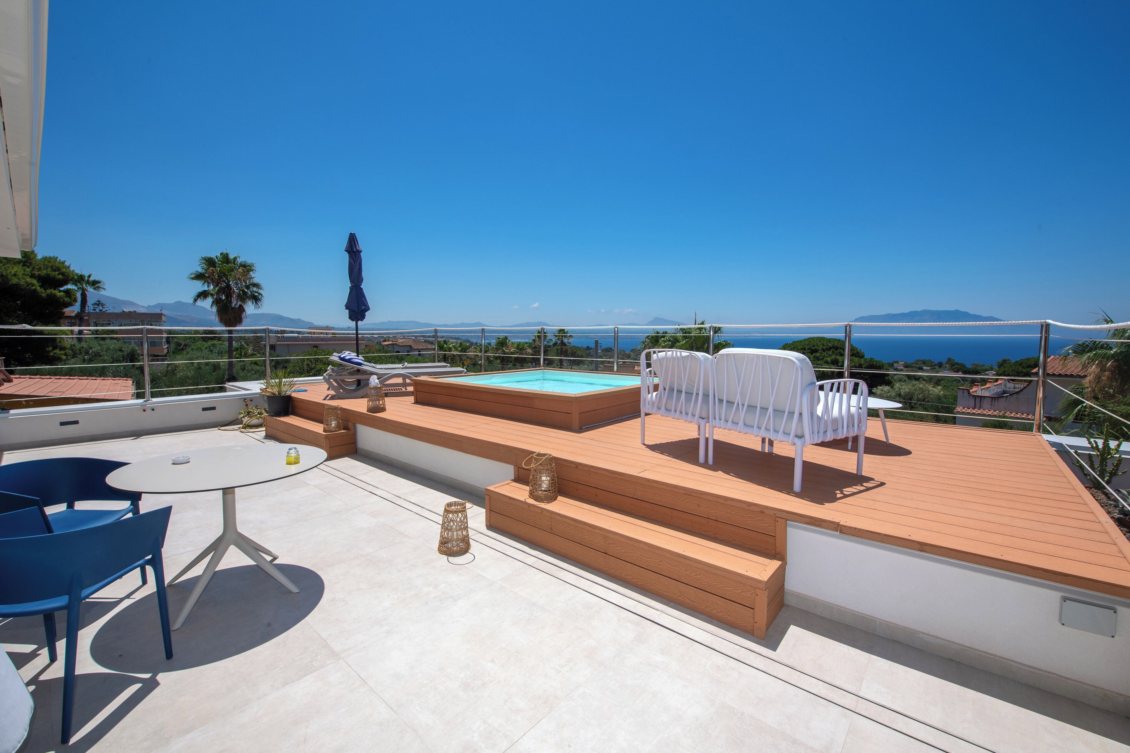 Une terrasse sur le toit avec une piscine, un espace salon et une vue sur la mer.