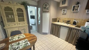 Una cocina compacta con comedor, un armario empotrado y una pequeña encimera.