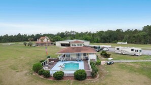 A large house with a swimming pool, RVs, and a golf cart. - Cozy retreat w/ pool & backyard (Clermont)