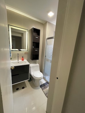 Et moderne badeværelse med toilet, vask og brusebad.