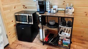 A compact kitchenette with a microwave, coffee maker, and a small fridge.