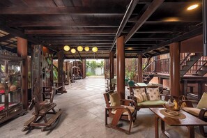 Um espaço amplo e interno com mobiliário de madeira, uma escada e vista para o exterior.