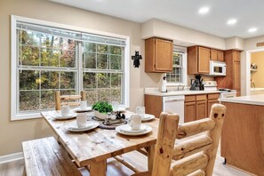Eine Küche mit Holzausstattung, einer Mikrowelle und einem Essbereich mit Tisch für vier Personen.