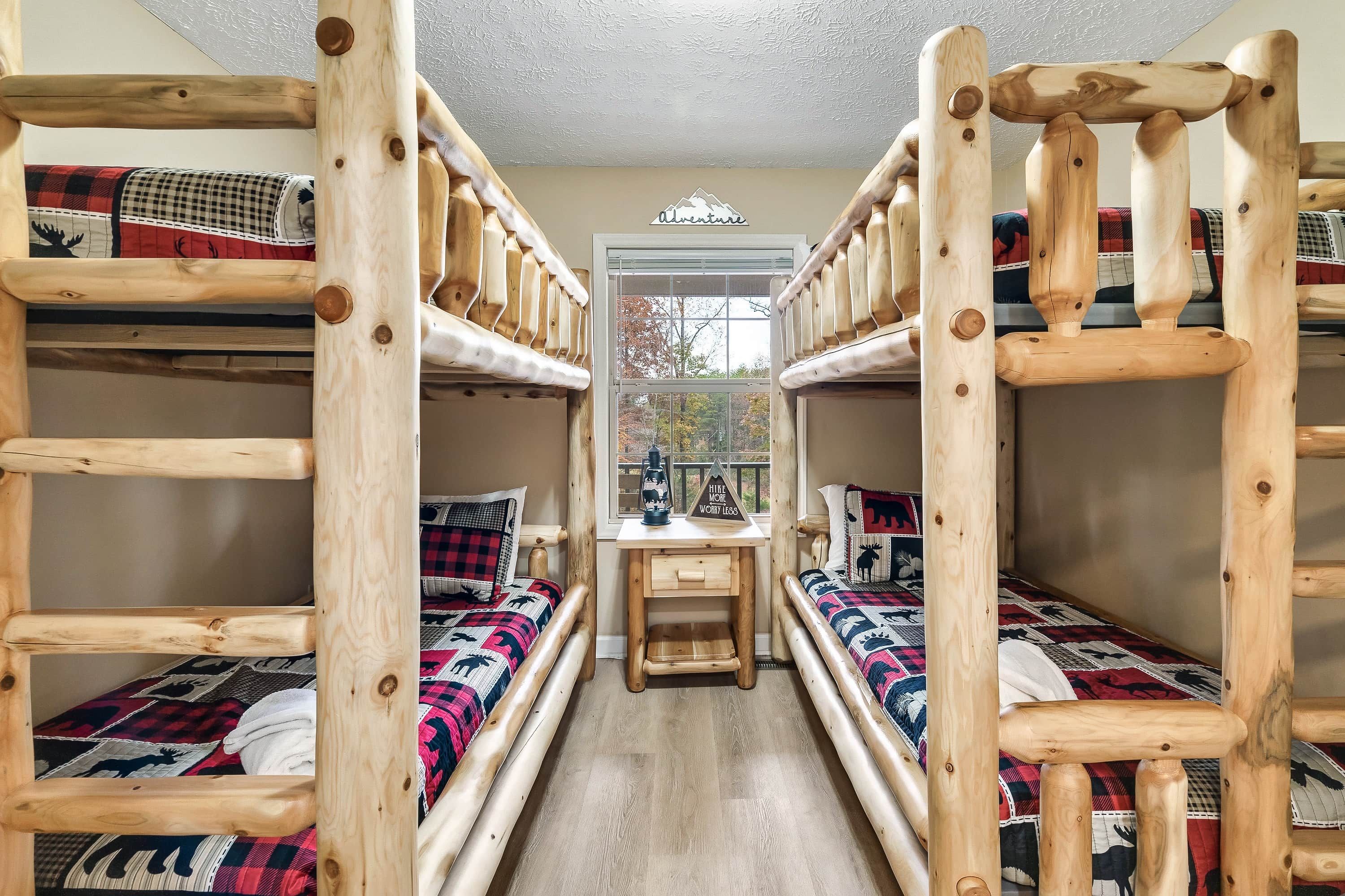 A bunk bed room with a desk and window, featuring a 'Adventure' sign and a 'Hire More, Work Less' sign.