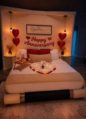 A bedroom with a bed, a bedside table, a wall decoration, and a nightstand.