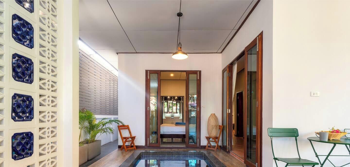A modern room with a bed, a small pool, and a view of the outdoors.