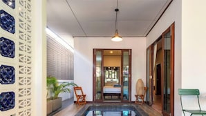 Una stanza moderna con un letto, una piccola piscina e vista sull'esterno.