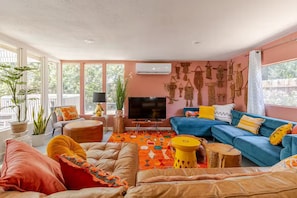 Ein Wohnzimmer mit einer Couch, Fernseher und Wanddekoration.