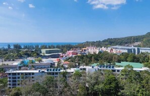 Un pueblo costero con una mezcla de edificios residenciales y comerciales, incluyendo un estadio grande y una zona festiva colorida.