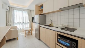 A modern kitchen with a built-in oven, a sink, and a dining area with a table and chairs. - Beach 3 Mins Fantasea Resort Kamala C190 (Tambon Kamala)