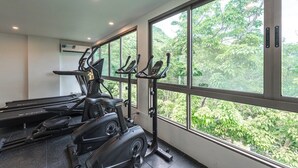 A gym with treadmills, stationary bikes, and a rowing machine, large windows with a view of greenery. - Beach 3 Mins Fantasea Resort Kamala C190 (Tambon Kamala)