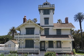 A two-story building with a prominent tower, a balcony, and a white picket fence. - Delightful Ocean Breeze 1-bedroom apartment in San Pedro (Los Angeles)