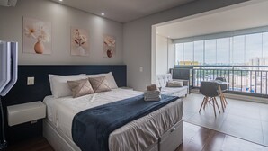 A modern bedroom with a large bed, a balcony with a view, and artwork on the walls. - Excellent Studio in S o Paulo - Sp-a1107 (São Paulo)