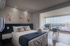 A modern bedroom with a large bed, a balcony with a view, and artwork on the walls. - Excellent Studio in S o Paulo - Sp-a1107 (São Paulo)