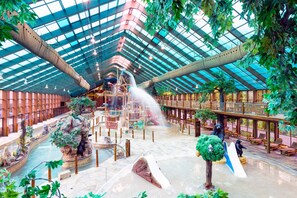 Ein Innenhof mit hoher Decke, Wasserspielen und Sitzbereichen.