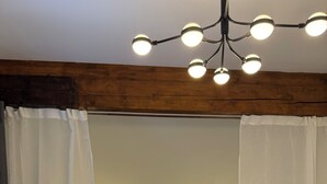 Een slaapkamer met een bed, een bedlampje en een plafondlamp.