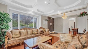A spacious living room with a large sofa set, a coffee table, and a chandelier.
