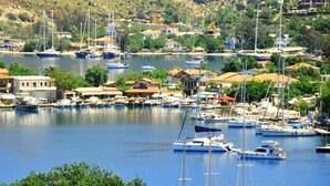 A marina with boats docked, surrounded by buildings and greenery. - Masal Tatil Evi  (Marmaris)