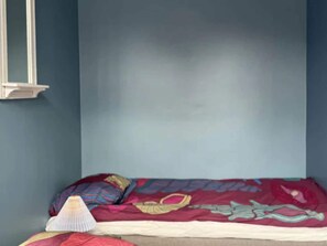 A bedroom with a single bed, a nightstand, and a wall-mounted heater. - 4 Star Holiday Home in Allinge (Allinge)