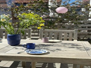 Ein Holztisch mit einer blauen Vase, einer blauen Tasse und einem blau-weißen Teller.