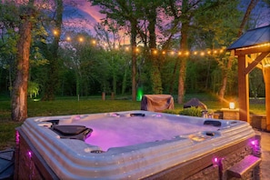 Ein Whirlpool inmitten eines bewaldeten Bereichs mit Lichterketten.