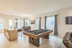 A modern living room with a pool table, a kitchen area, and a dining space. - Spacious King Ste Pool Table, Mins to NoDa & UPTWN! (Charlotte)