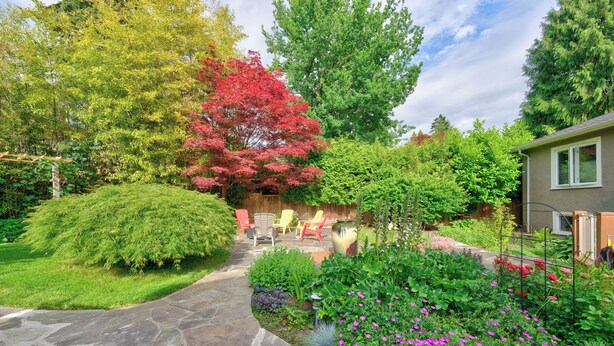 A stone pathway leading to a house with a garden, outdoor furniture, and a variety of plants. - Tranquil Garden Level Retreat near UBC & Airport (Vancouver)