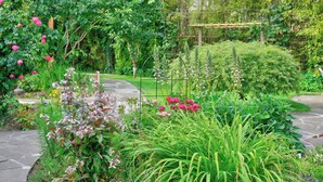 A garden with a variety of plants and flowers, a wooden pergola, and a stone pathway. - Tranquil Garden Level Retreat near UBC & Airport (Vancouver)
