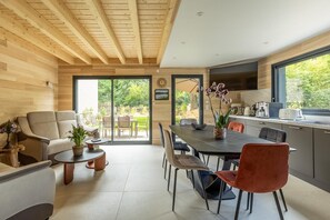 Eine moderne Küche mit Essbereich, Holzboden und großen Fenstern.