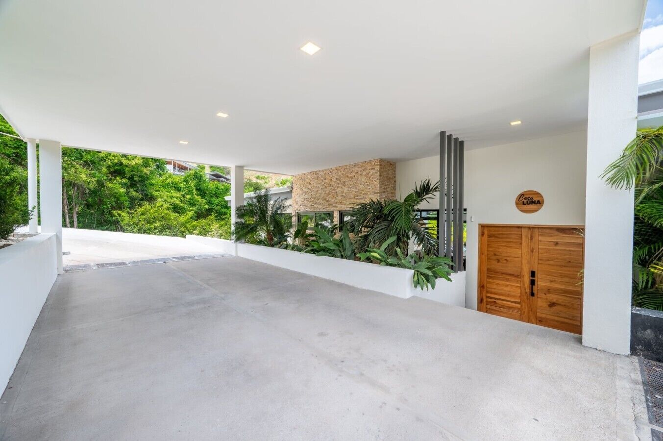 A modern building with a concrete floor, a brick wall, and a wooden door.