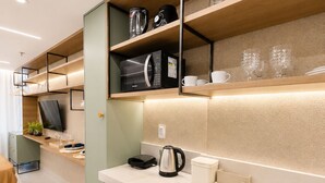 A modern kitchen with a built-in microwave, coffee maker, and a compact refrigerator. - Nawi Beachfront Escape Apartment - Pool, Gym & Ocean Access (João Pessoa)