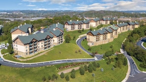 Un complejo residencial con varios edificios de apartamentos, césped verde y una calle curva.